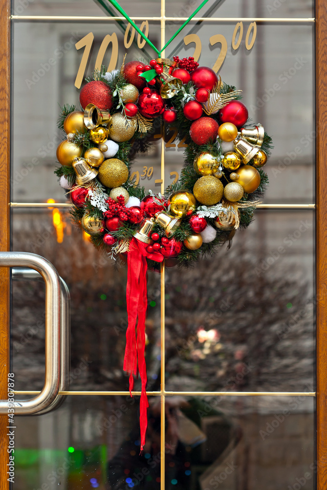 Christmas wreath for doors close up. Handmade decorative ornament. Round wreath with colored toys and ribbons.