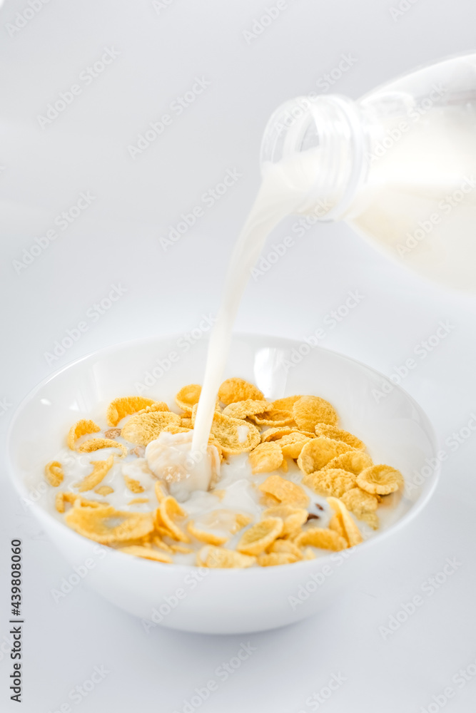 cornflakes with milk in a plate on a white background. dry quick breakfast. american food cornflakes with milk in a plate on a white background. dry quick breakfast. american food