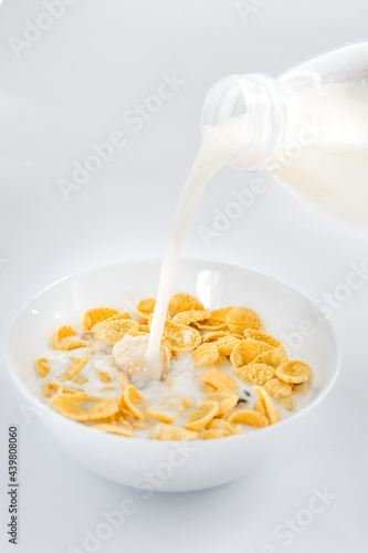 cornflakes with milk in a plate on a white background. dry quick breakfast. american food