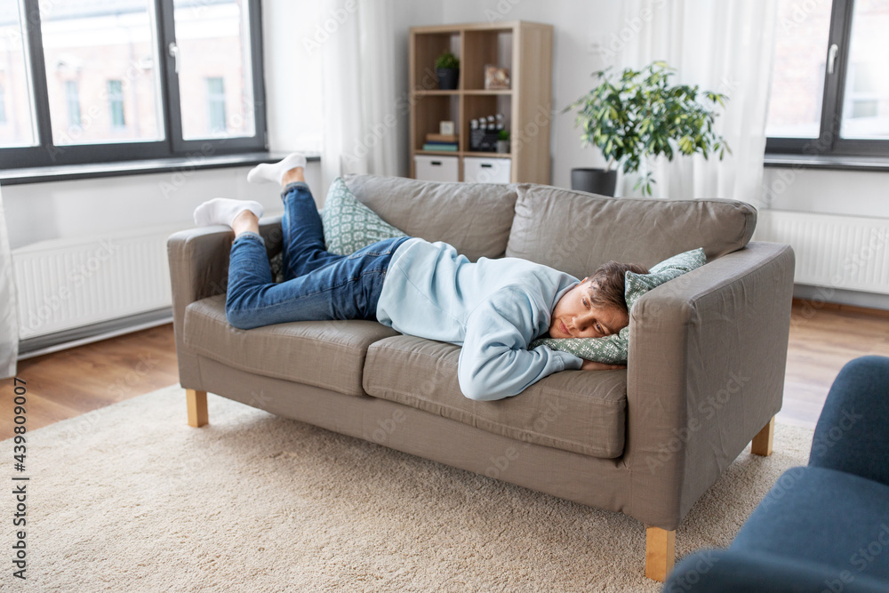 people, boredom and depression concept - bored or lazy young man lying on sofa at home people, boredom and depression concept - bored or lazy young man lying on sofa at home
