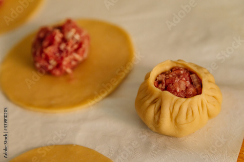 Steamed national Mongolian food dumpling Buuz filled with minced beef, white serviette, wooden table, Close up east Siberian Buryats dish poses, Juicy minced meat wrapped handmade dough shirt buuza