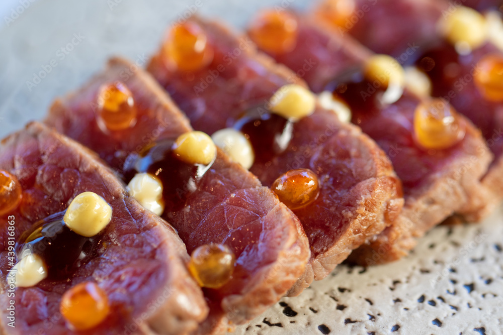 Macro detail of wagyu beef tataki morsel. Macro detail of wagyu beef tataki morsel.