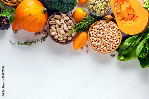 Pumpkin, nuts, peppers, herbs, chickpeas on a white plate with copy space. View from above.