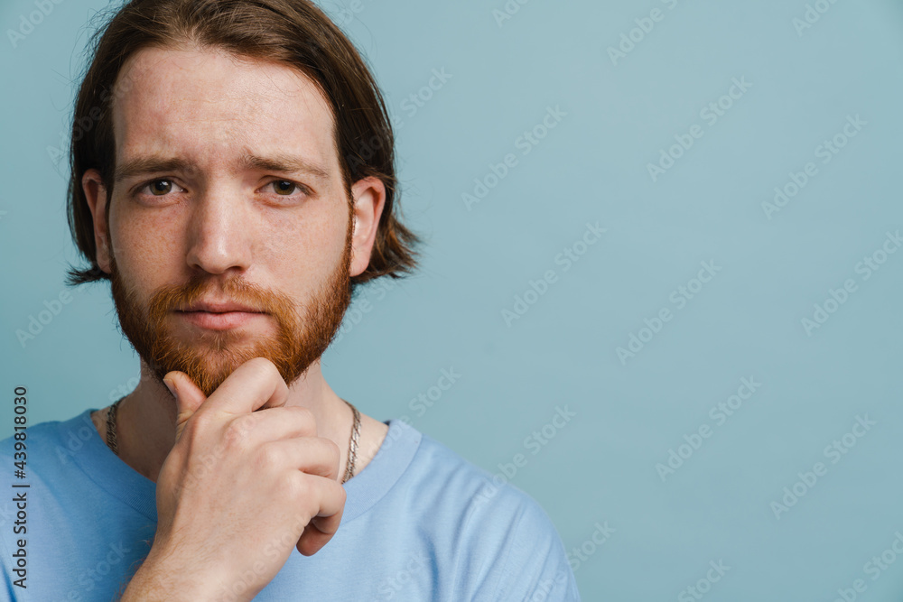 Young ginger man with beard posing and looking at camera