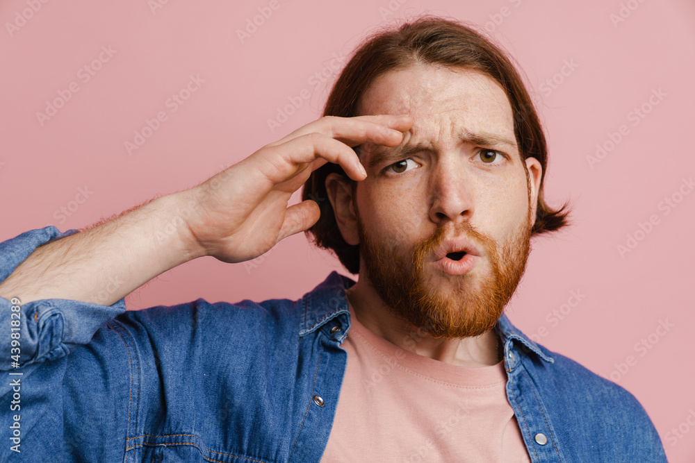 Young ginger man with beard expressing surprise at camera Young ginger man with beard expressing surprise at camera