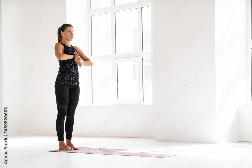 Young white woman doing exercise during yoga practice indoors