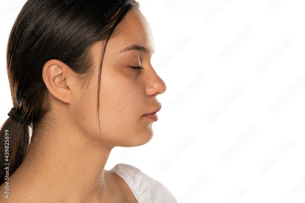 Profile of a young beautiful woman with closed eyes on a white background Profile of a young beautiful woman with closed eyes on a white background
