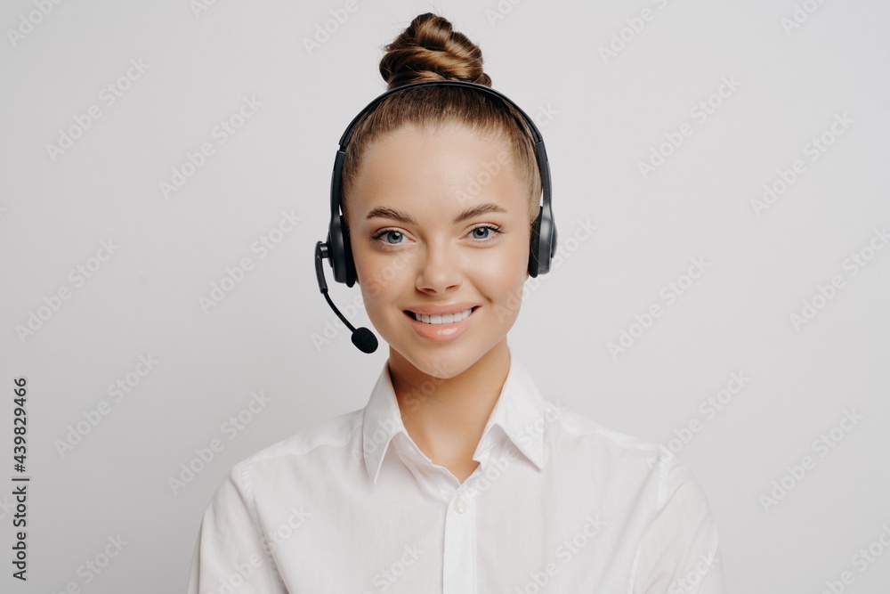 Female call center worker in white shirt smiling at camera Female call center worker in white shirt smiling at camera