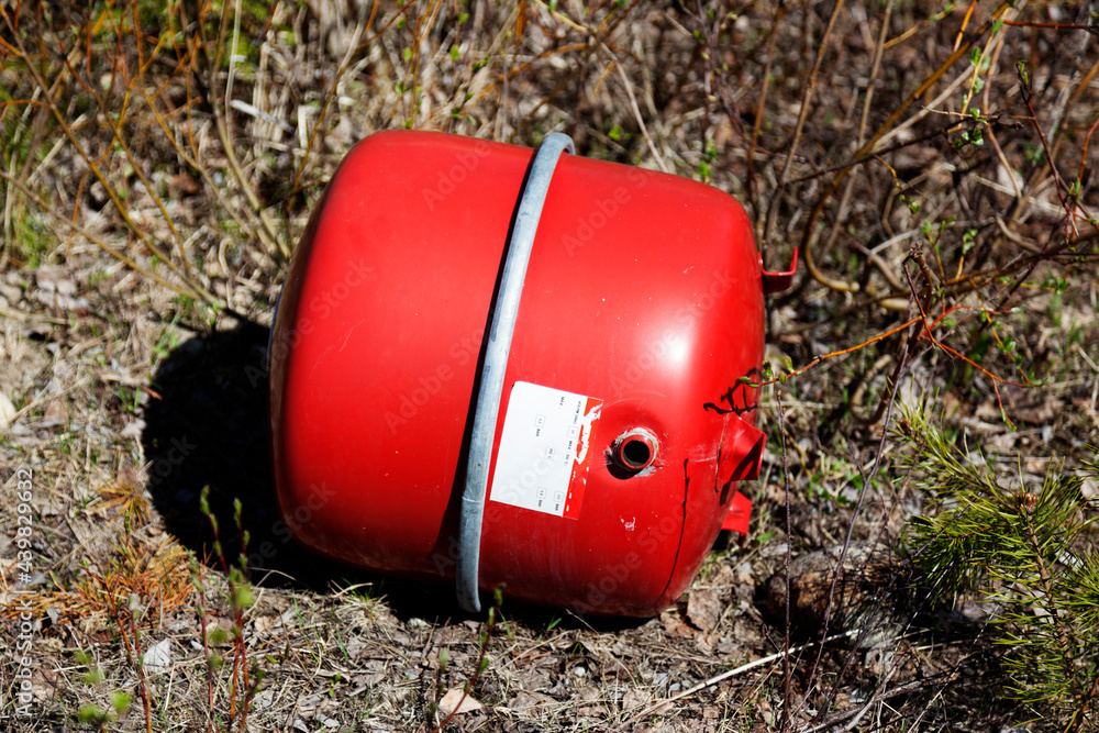 a red glass bottle that can withstand pressure that someone has thrown into the woods a red glass bottle that can withstand pressure that someone has thrown into the woods