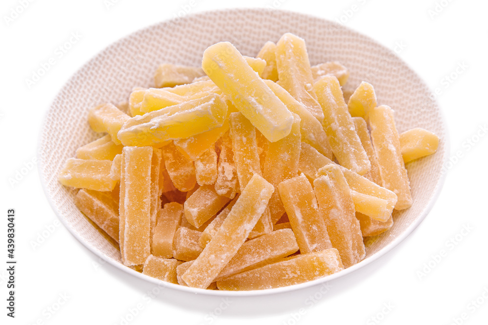 Candied fruits.Sugar-coated ginger sticks in a white plate on a white background. Isolated items and products Candied fruits.Sugar-coated ginger sticks in a white plate on a white background. Isolated items and products