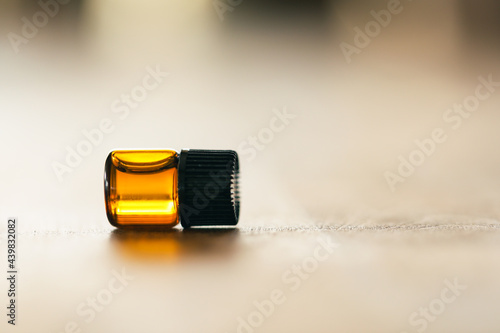 Close up image of 1ml amber essential oil vial. Health and wellness sample with copy space. photo