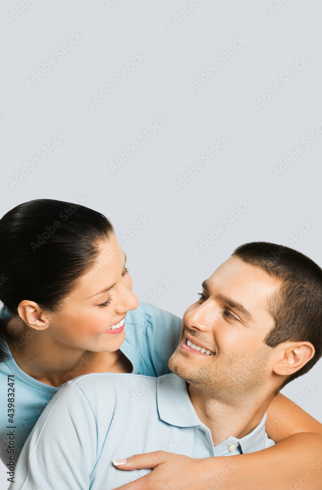 Smiling happy amazed couple. Portrait image of standing close attractive models in love studio concept, isolated on grey color background. Young man and woman posing together. Smiling happy amazed couple. Portrait image of standing close attractive models in love studio concept, isolated on grey color background. Young man and woman posing together.
