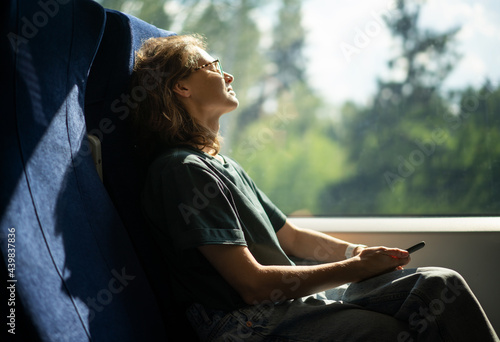 Obraz na płótnie Young beautiful woman wearing glasses sitting in a chair in a high-speed train relaxing while traveling w salonie