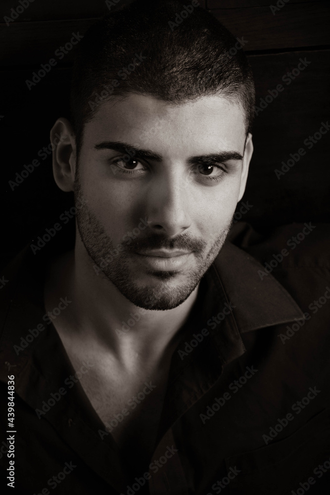 Portrait of handsome man with beard looking at camera with dark eyes Portrait of handsome man with beard looking at camera with dark eyes