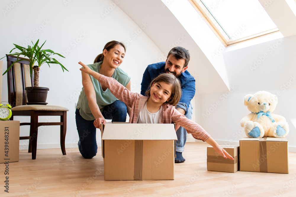 Happy family moving and riding in cardboard boxes at new home. Happy family moving and riding in cardboard boxes at new home.