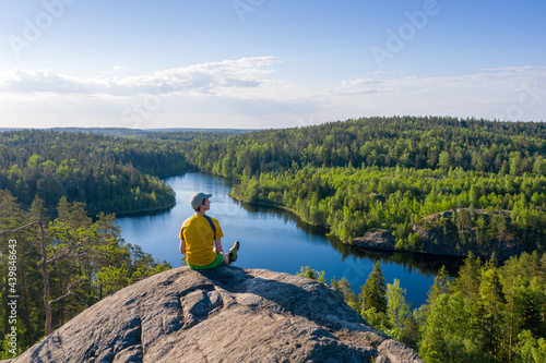 Man sits on the top and contemplates the world of outdoor.
