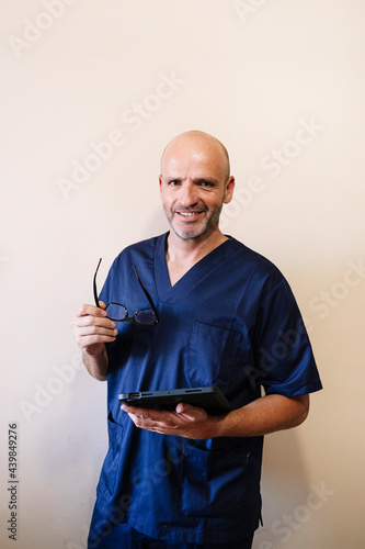 Studio portrait of smiling doctor with tablet healthcare worker