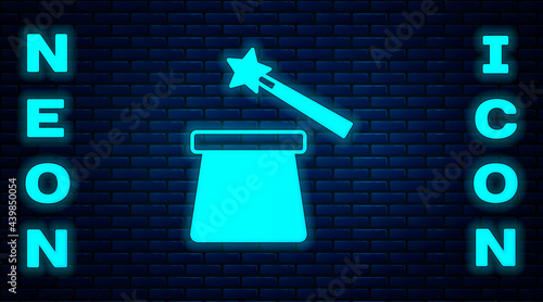 Glowing neon Magic hat and wand icon isolated on brick wall background. Magic trick. Mystery entertainment concept. Vector