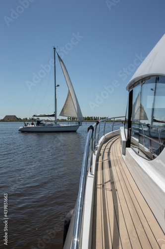 Yacht. Motor boat. Pleasure boat. Pleasure cruising. Frisian canals. Friesland. Luxury ship. Water cruising. Leisure. Summer. Netherlands. On deck. Sailing boat.
