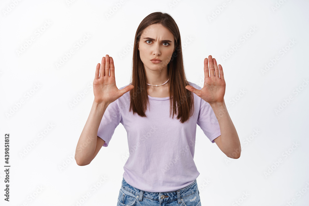 Stop it, no. Serious angry woman raise hands in block, stay back, prohibit or reject something, declining outrageous offer, standing confident against white background Stop it, no. Serious angry woman raise hands in block, stay back, prohibit or reject something, declining outrageous offer, standing confident against white background