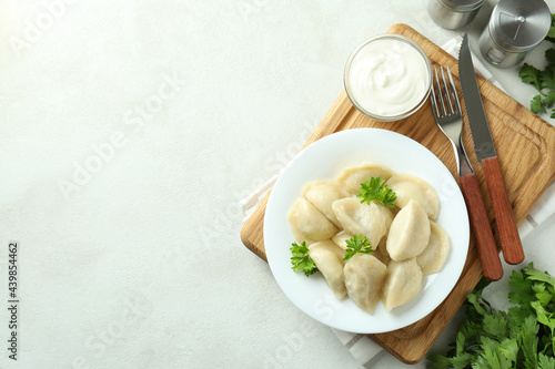 Concept of tasty food with vareniki or pierogi on white textured table