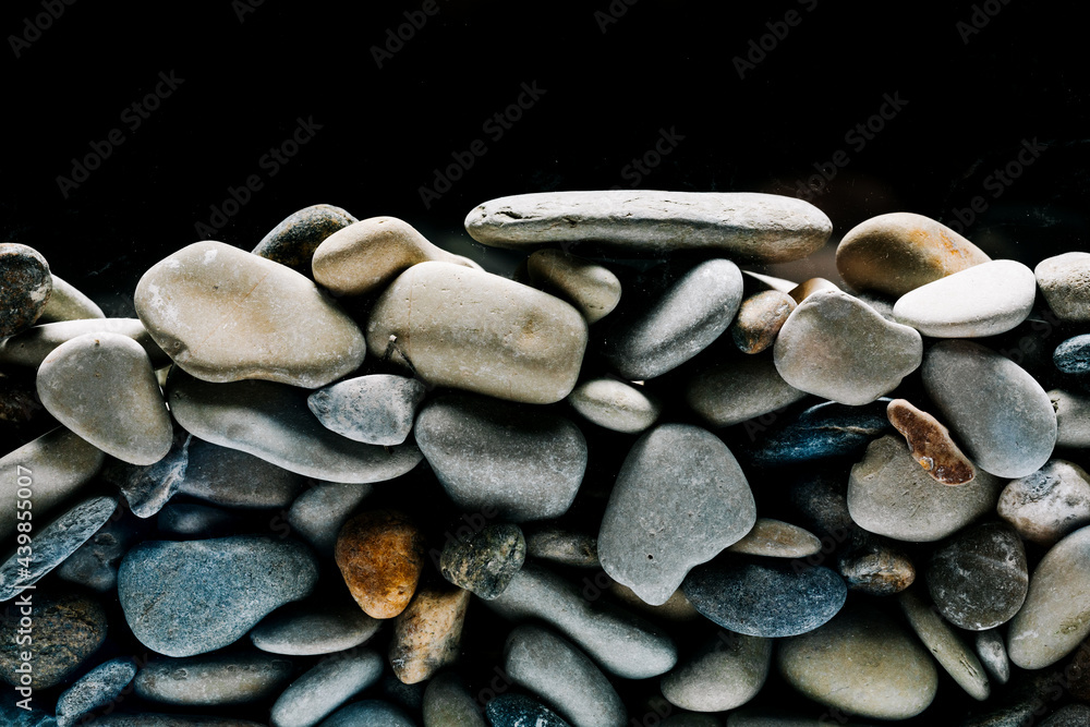 Fototapeta premium Colorful sea pebbles close-up. Background texture, sea stones in the water