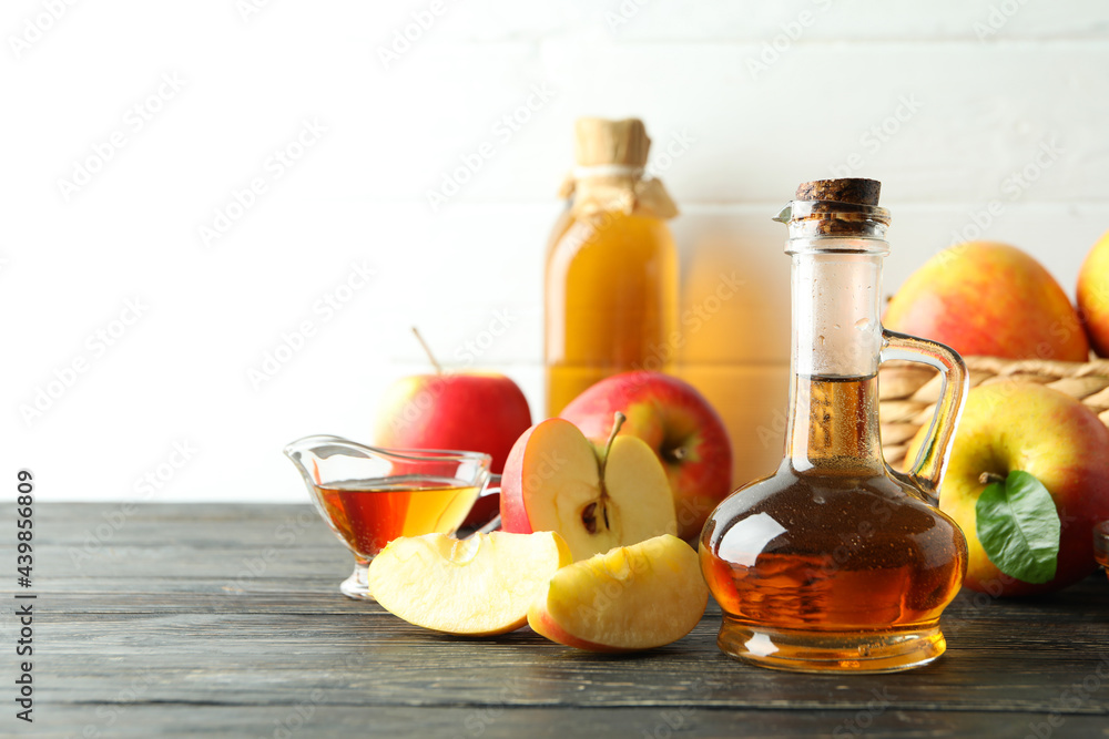 Homemade apple vinegar and ingredients on wooden table Homemade apple vinegar and ingredients on wooden table