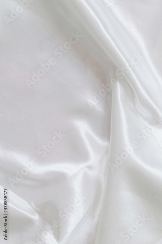 Beautifully draped white satin fabric. Minimalistic layout for you design. Copy space