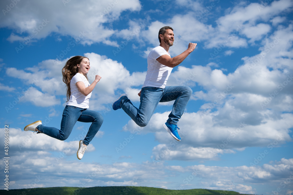 father and daughter jump high. hurry up. happy childhood and fatherhood. concept of friendship father and daughter jump high. hurry up. happy childhood and fatherhood. concept of friendship