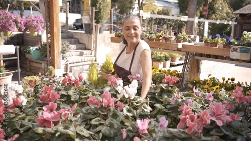 Stock video of beautiful middle age woman working in plant nursery.