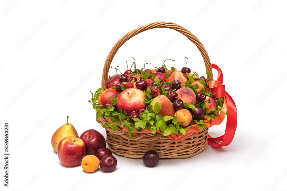Basket with fresh fruits and berries on a white background