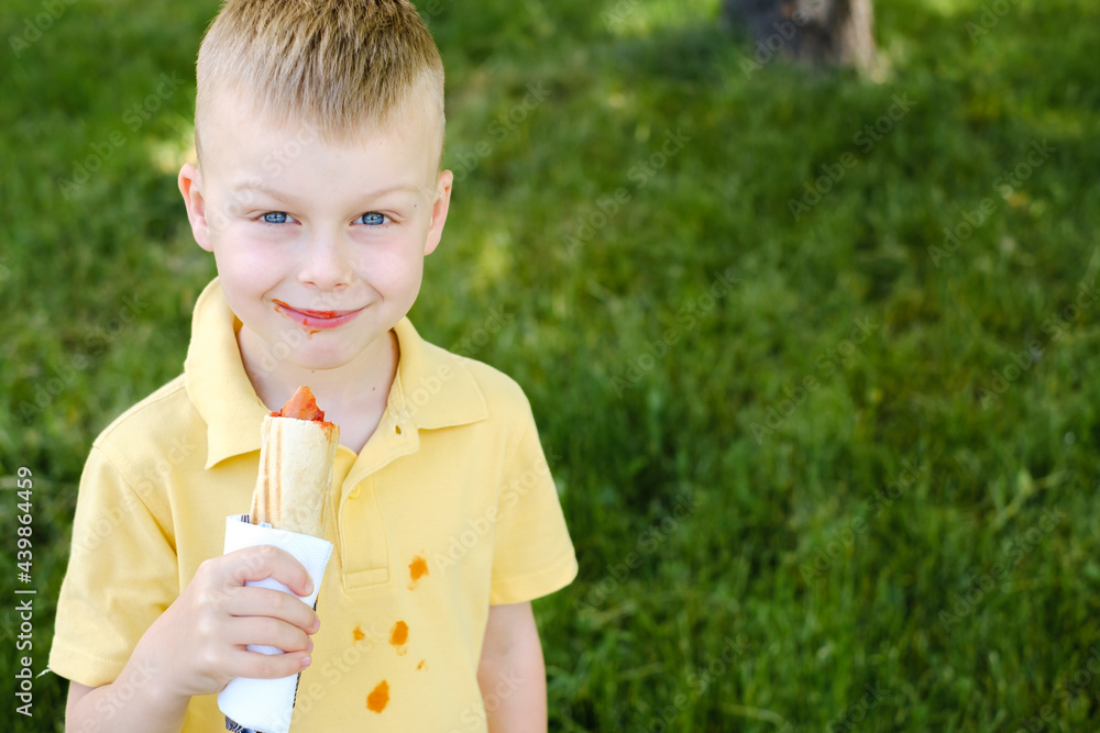 Cute dirty boy in ketchup among the grass Cute dirty boy in ketchup among the grass