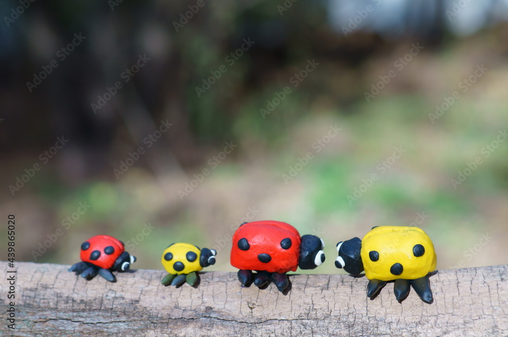Two small and two large ladybugs on a colored background. Two small and two large ladybugs on a colored background.