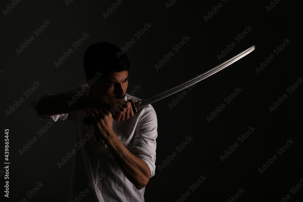 Fighter with katana sword in shadows Fighter with katana sword in shadows