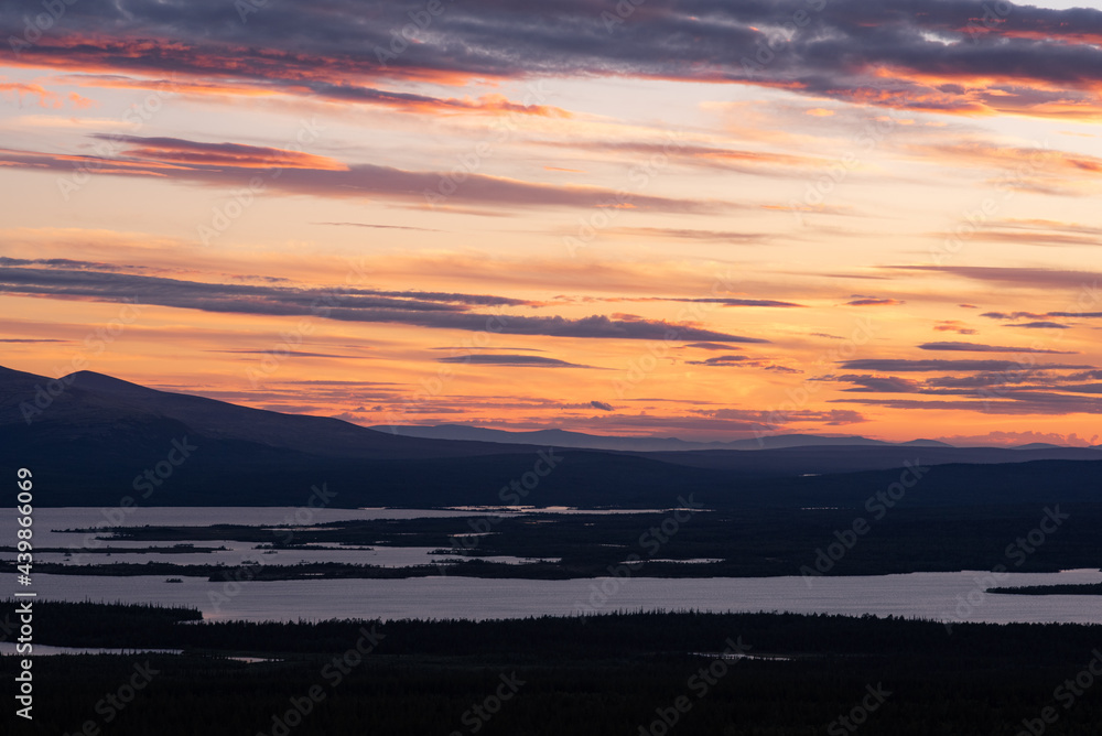 Wonderful sunset over the lake, forest and northern mountains of the Kola Peninsula