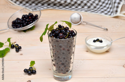 still life with black currants in a glass on the kitchen table