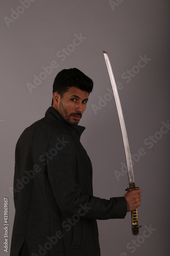 A man with katana sword on gray background