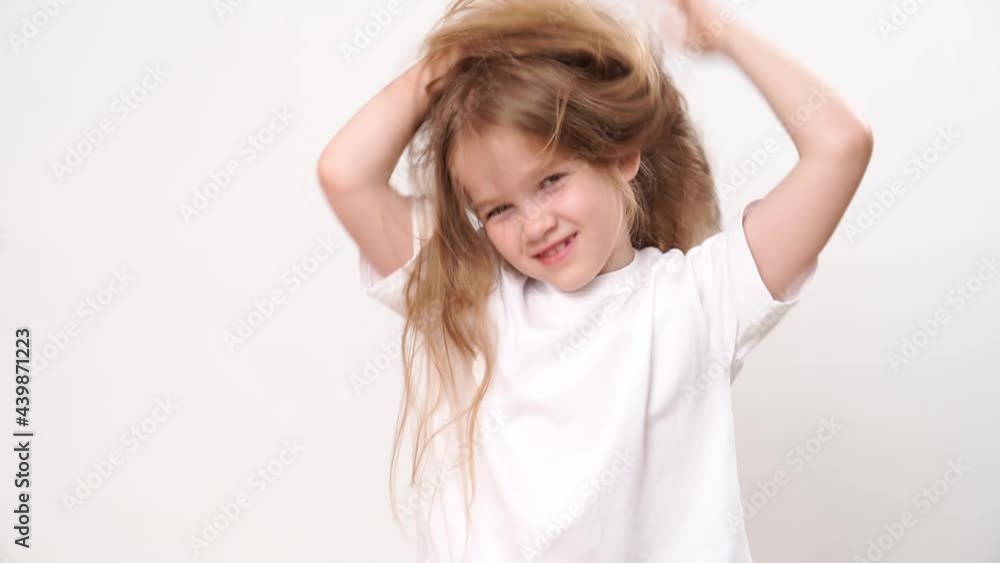 Little girl ruffles long blond hair on her head. child's hair care. shampoo and combing. Little girl ruffles long blond hair on her head. child's hair care. shampoo and combing.