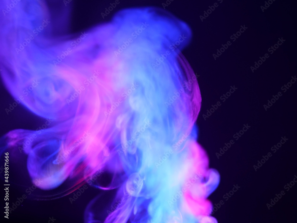 Obraz premium Abstract color series. Composition of colorful smoke in motion. Fusion of purple and blue mist isolated on a dark background to inspire creativity.