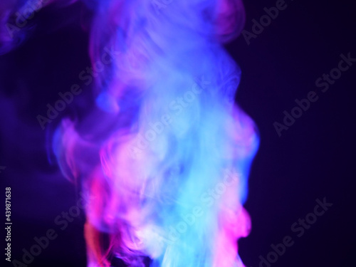Abstract color series. Composition of colorful smoke in motion. Fusion of purple and blue mist isolated on a dark background to inspire creativity.