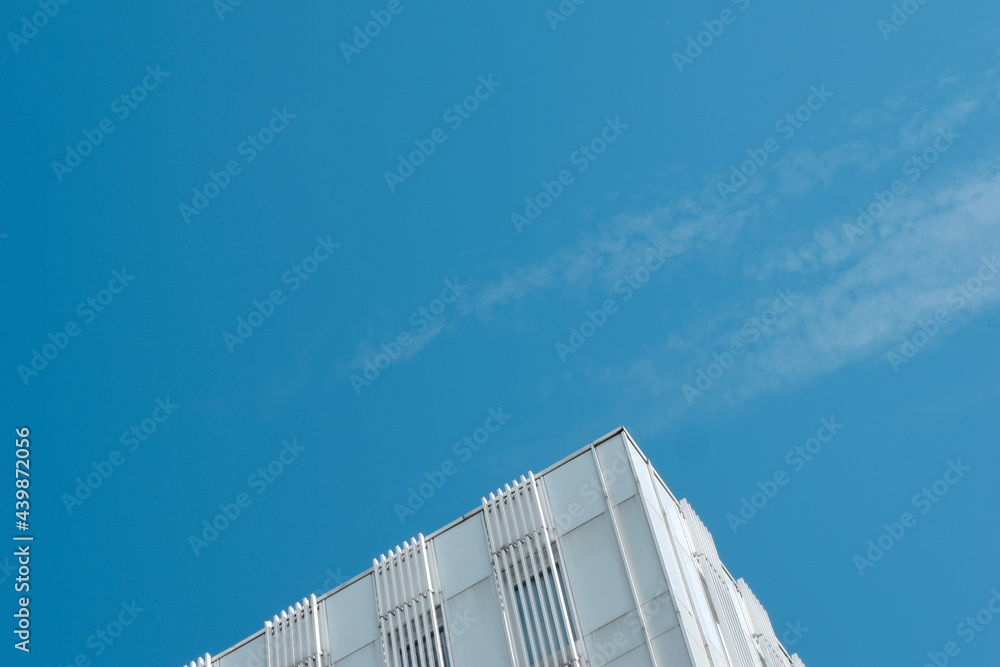 Fototapeta premium Minimal background with falling corner of white building against the blue sky with cloud