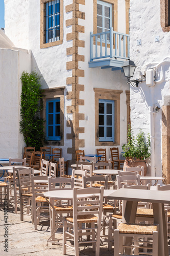 Wooden outdoor furniture of street cafe in old greek town.