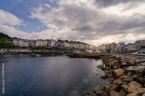 Beautiful sunset on the seaport next to the houses and filled of fishing boats in Malpica town Galicia Spain