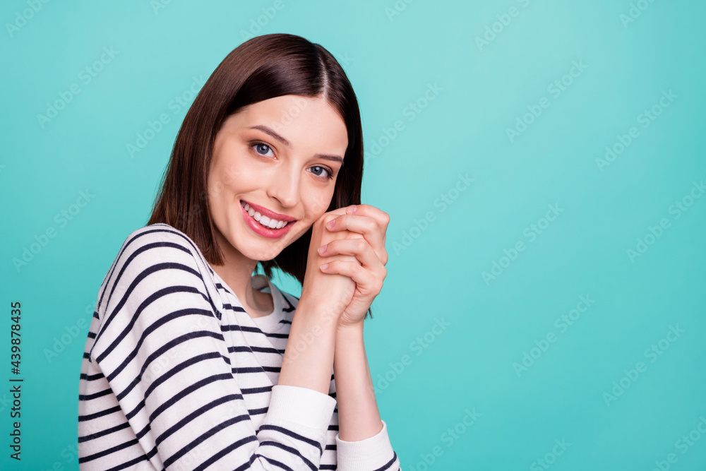 Fototapeta premium Photo of adorable cute grateful lady hold hands toothy smile wear striped shirt isolated on teal color background