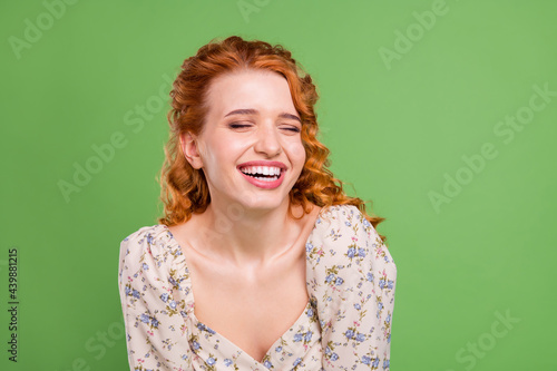 Photo of cheerful young joyful woman smile joke funny good mood face isolated on green color background