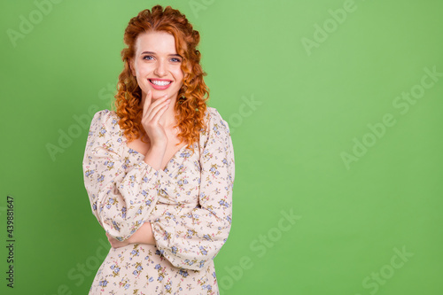 Photo of positive happy nice young woman hold hand chin good mood think isolated on green color background © deagreez