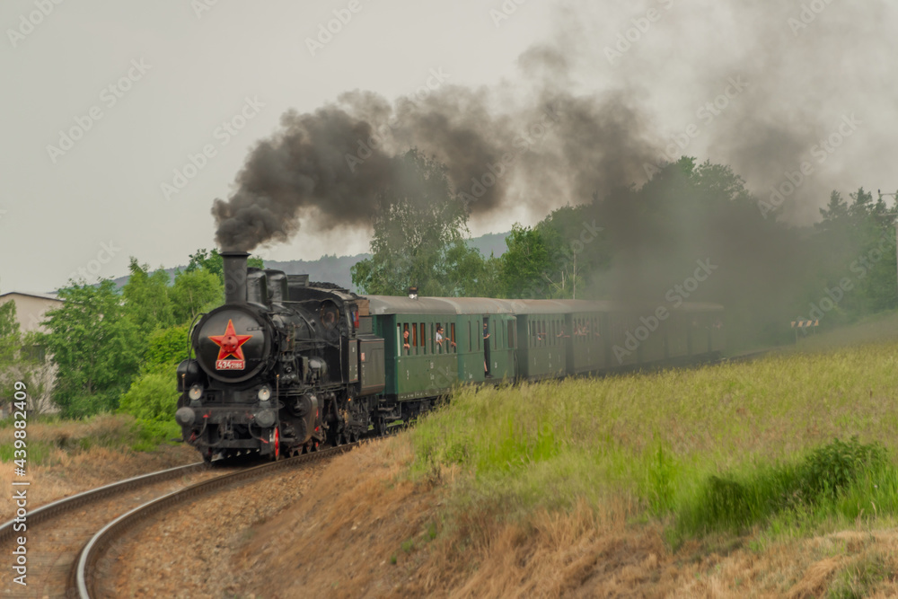 Steam train near Sazava river in south of Prague in summer cloudy day Steam train near Sazava river in south of Prague in summer cloudy day