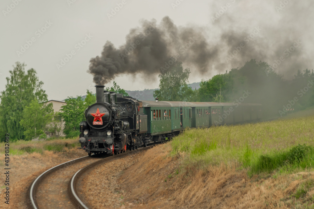 Steam train near Sazava river in south of Prague in summer cloudy day Steam train near Sazava river in south of Prague in summer cloudy day