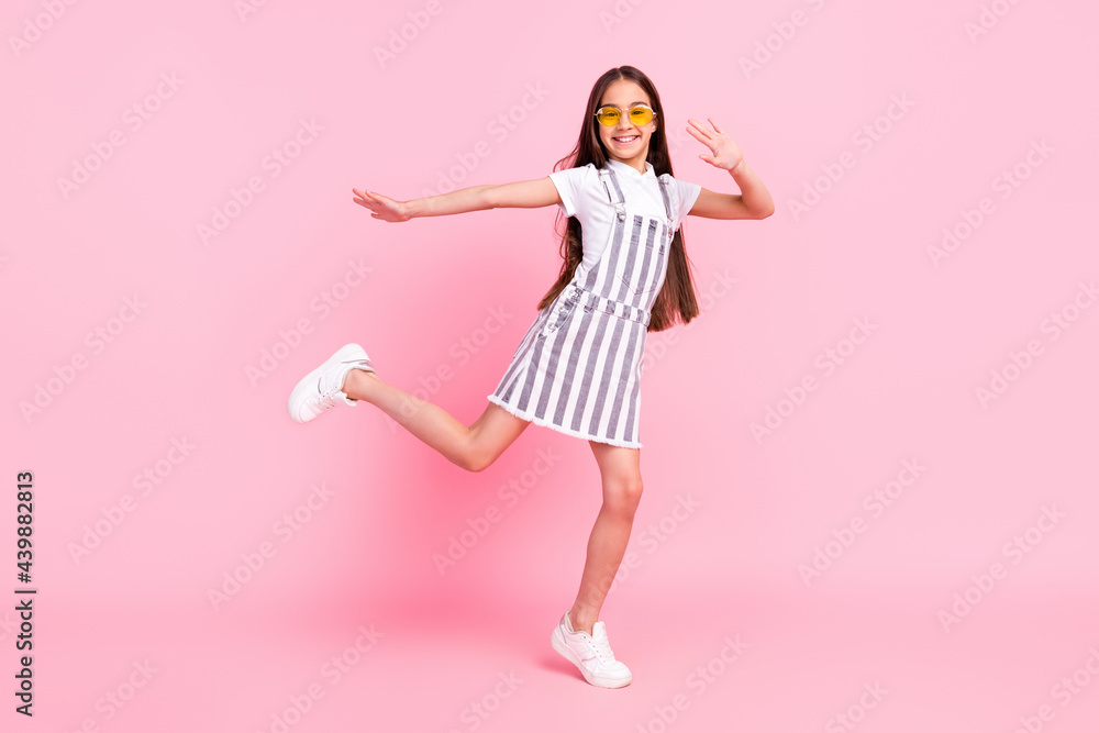 Full length body size photo schoolgirl overall glasses dancing at party overjoyed isolated pastel pink color background Full length body size photo schoolgirl overall glasses dancing at party overjoyed isolated pastel pink color background