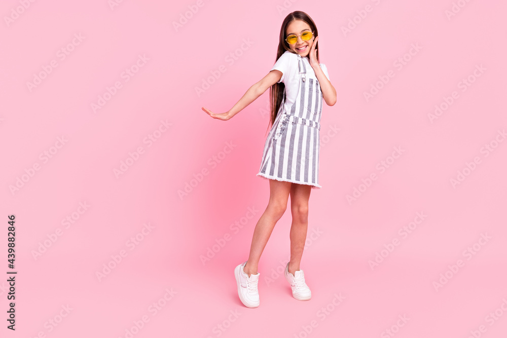 Full size photo of charming nice pretty young girl good mood wear sunglass isolated on pastel pink color background Full size photo of charming nice pretty young girl good mood wear sunglass isolated on pastel pink color background